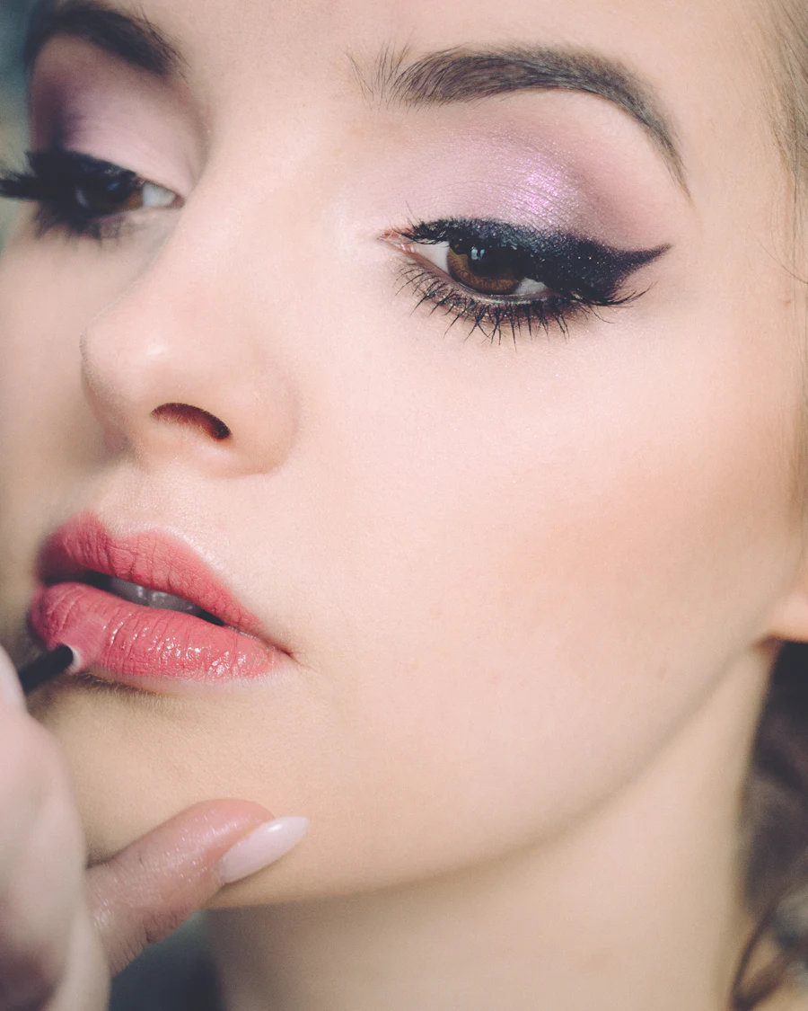 Makeup artist applying lipstick on a client